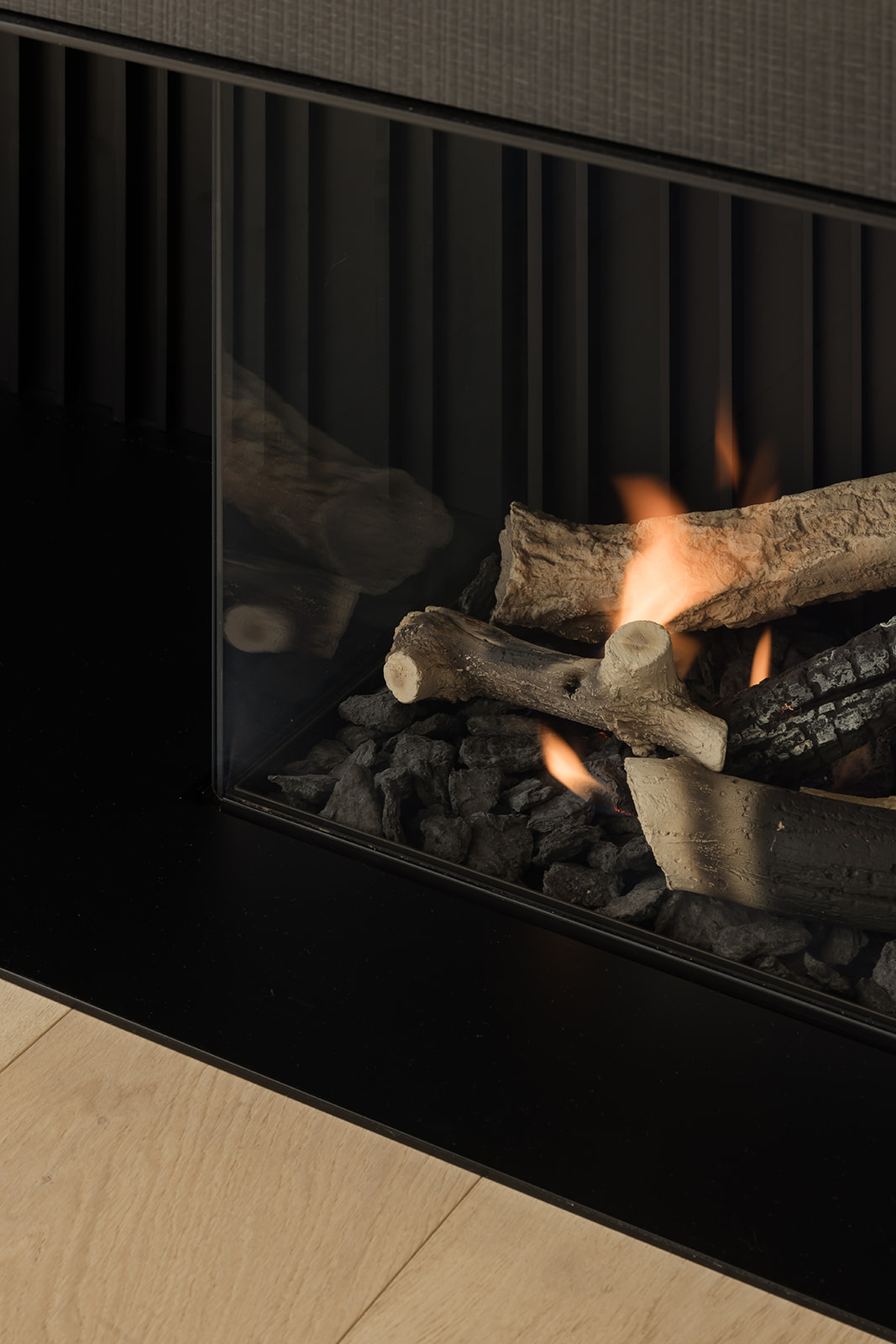 Detailopname van een ingebouwde haard met realistische houtblokken, perfect voor het creëren van een warme sfeer in huis.